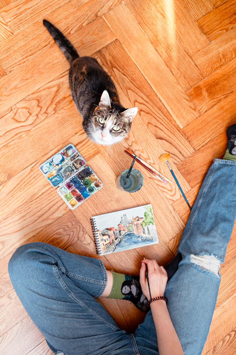 Helen beim Malen und Gestalten auf dem Boden mit Katze
